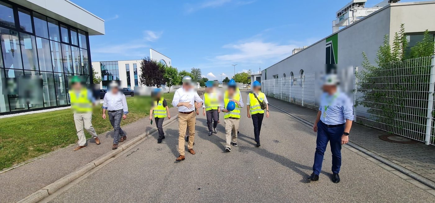 Participants in helmets and safety vests on a guided industrial site visit